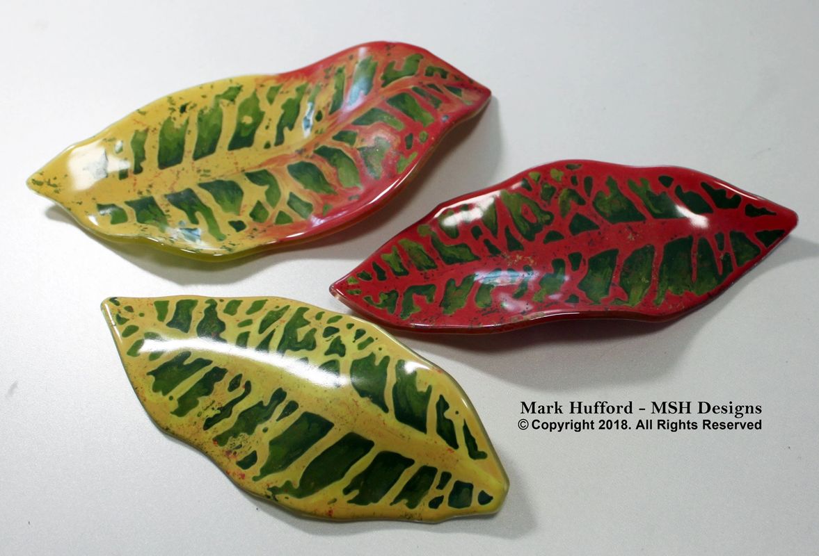 Three colorful leaf-shaped kiln-formed glass dishes